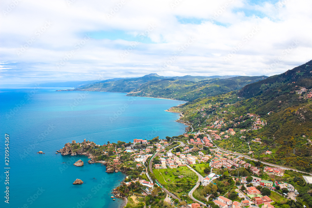 Beautiful view of picturesque Sicilian village on the Tyrrhenian coast from above captured from Rocca di Cefalu, Italy. Hilly landscape in background. Cefalu is a major tourist destination in Italy
