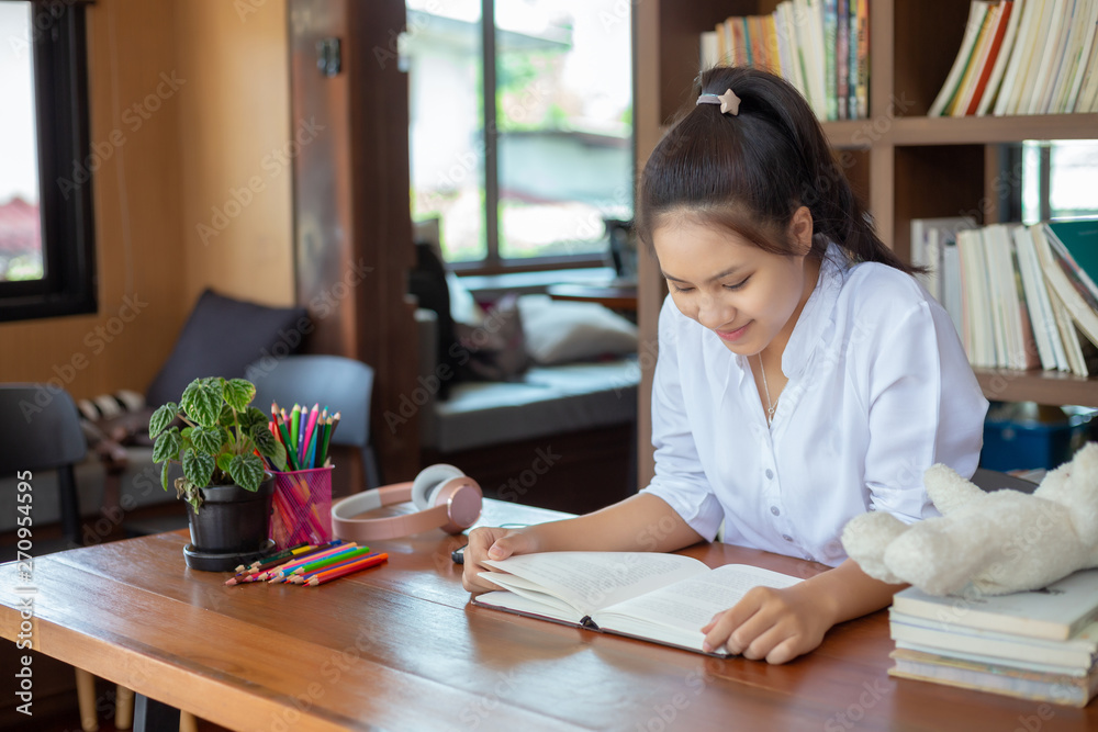 Pretty female student reading test preparation in the libraries of University. Pretty female student reading test preparation in the libraries of University.
