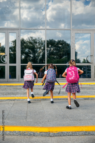 Group of elementary school kids running at school, back view © Elena Kratovich