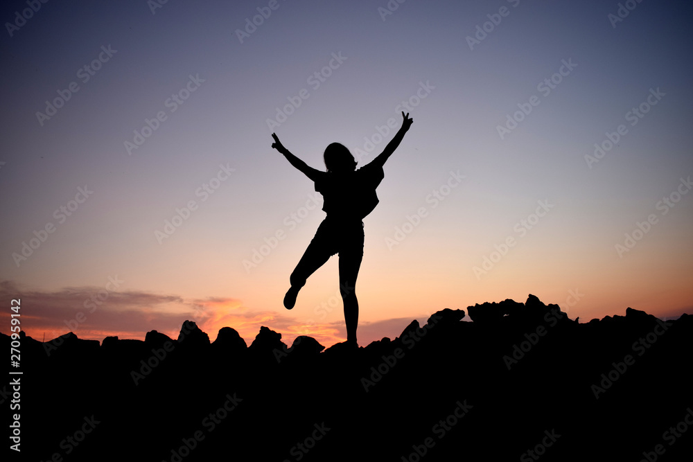 silhouette of a girl jumping in the sunset