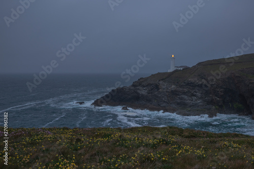 Lighthouse by the ocean on a gloomy evening on Cornwalls North coast, uk