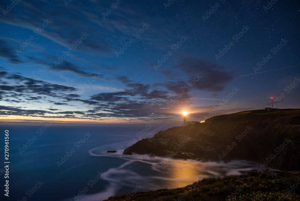 Fototapeta premium Starry night sky with clouds at Trevose head on Cornwalls North coast, UK