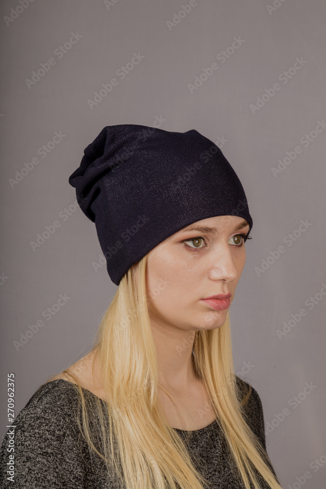 Portrait of a beautiful young girl in a stylish headdress with natural makeup on a gray background. Portrait of a beautiful young girl in a stylish headdress with natural makeup on a gray background.