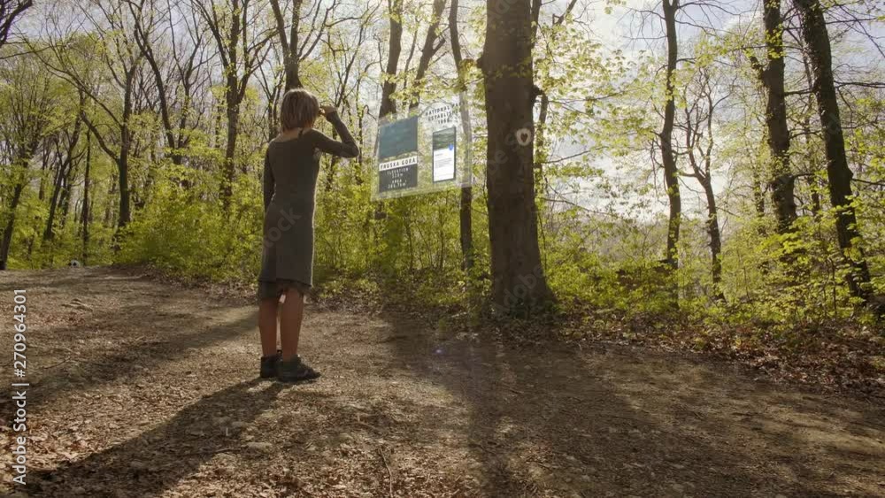 Girl uses augmented reality to learn about the tree in the forest