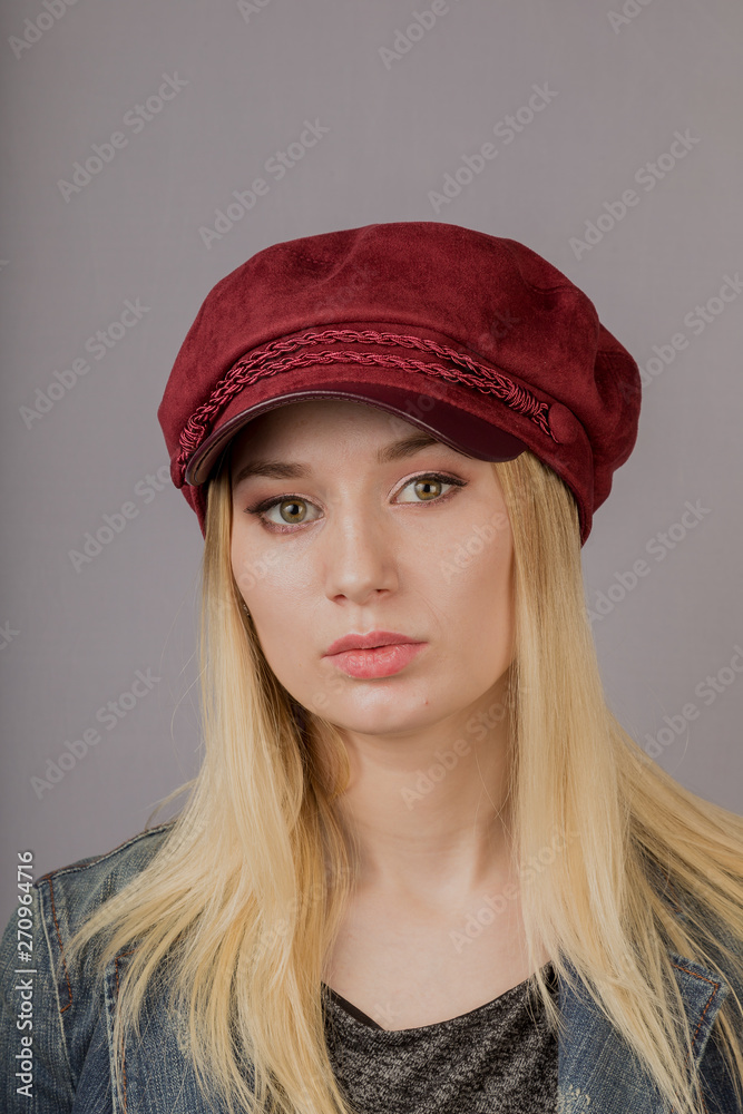 Portrait of a beautiful young girl in a stylish headdress with natural makeup on a gray background. Portrait of a beautiful young girl in a stylish headdress with natural makeup on a gray background.