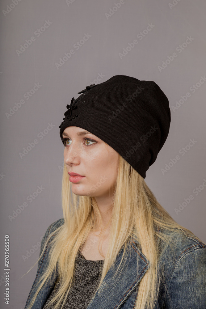 Portrait of a beautiful young girl in a stylish headdress with natural makeup on a gray background. Portrait of a beautiful young girl in a stylish headdress with natural makeup on a gray background.