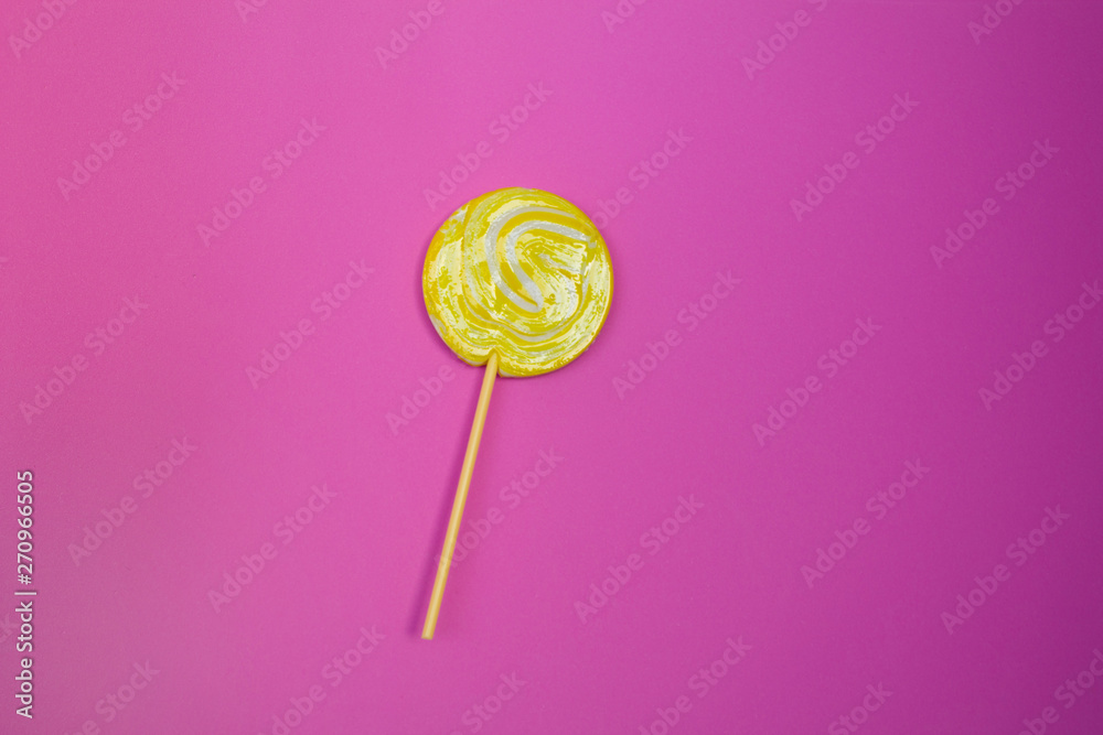 Yellow lollipop on delicate pink background Yellow lollipop on delicate pink background