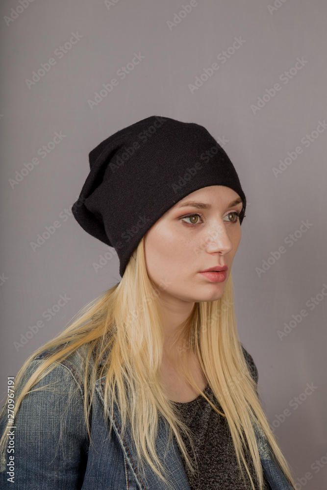 Portrait of a beautiful young girl in a stylish headdress with natural makeup on a gray background. Portrait of a beautiful young girl in a stylish headdress with natural makeup on a gray background.