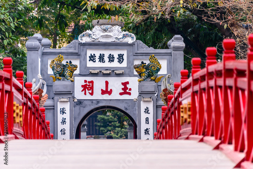The iconic red painted Huc Bridge over Ho Hoan Kiem Lake, Hanoi, Vietnam which leads to the Den Ngoc Son Confucious Temple. photo