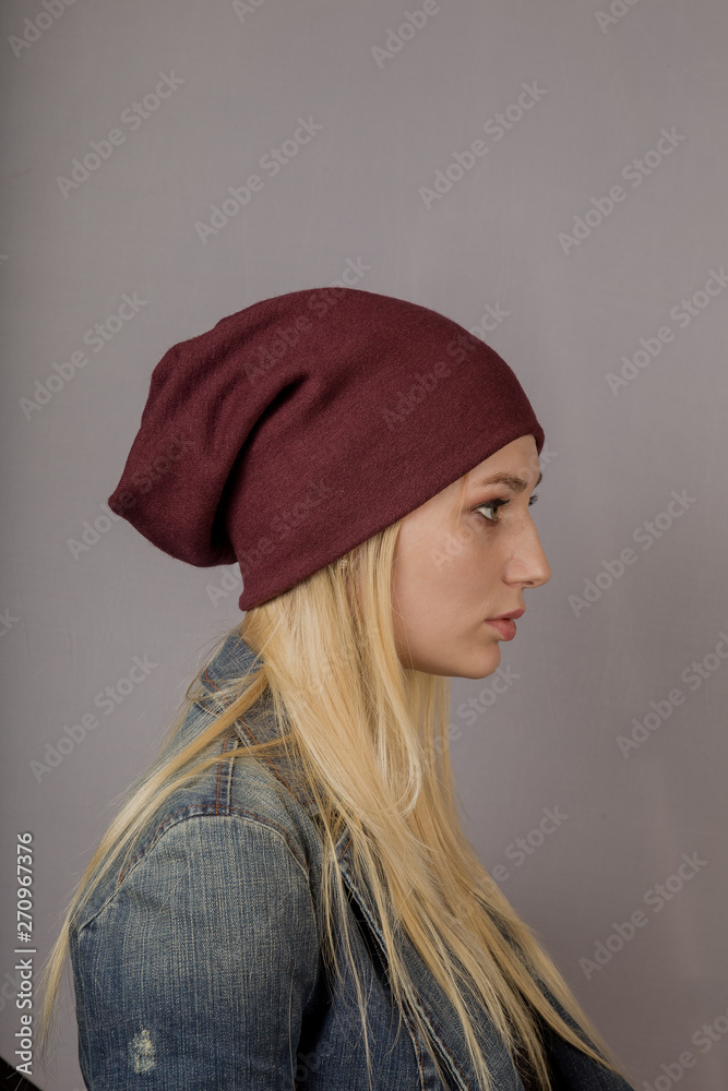 Portrait of a beautiful young girl in a stylish headdress with natural makeup on a gray background. Portrait of a beautiful young girl in a stylish headdress with natural makeup on a gray background.