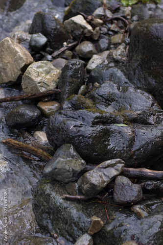 Dark background of Wet stones in mountain river