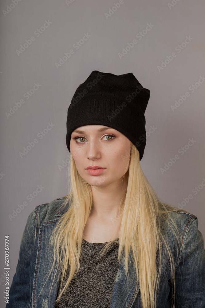 Portrait of a beautiful young girl in a stylish headdress with natural makeup on a gray background. Portrait of a beautiful young girl in a stylish headdress with natural makeup on a gray background.
