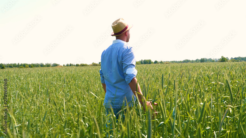 Portrait of a young young man in a straw hat runs and jumps on a wheat field feeling something like a force. Concept of: Slow shooting, Lifestyle. Portrait of a young young man in a straw hat runs and jumps on a wheat field feeling something like a force. Concept of: Slow shooting, Lifestyle.