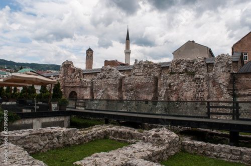 Bosnia: the Sarajevo Clock Tower built by ottoman governor Gazi Husrev-beg, and the minaret of Gazi Husrev-beg Mosque seen from the remains of Taslihan, a 1540 stone inn and  caravanserai photo