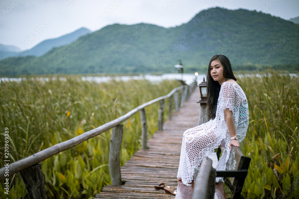 Fototapeta premium Woman sitting on a pier