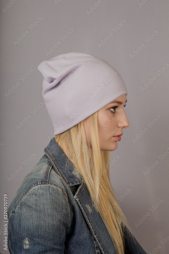 Portrait of a beautiful young girl in a stylish headdress with natural makeup on a gray background. Portrait of a beautiful young girl in a stylish headdress with natural makeup on a gray background.