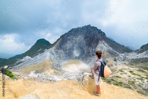 Sibayak volcano, active caldera steaming, famous travel destination natural landmark and tourist attraction in Berastagi Sumatra Indonesia. Tourist looking at view from the top, traveling people.
