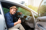 Young asian man showing thumbs up while driving car with copy space.