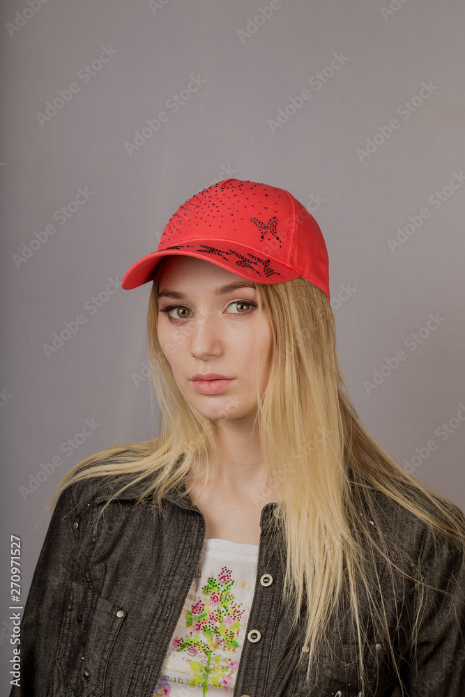 Portrait of a beautiful young girl in a stylish headdress with natural makeup on a gray background. Portrait of a beautiful young girl in a stylish headdress with natural makeup on a gray background.