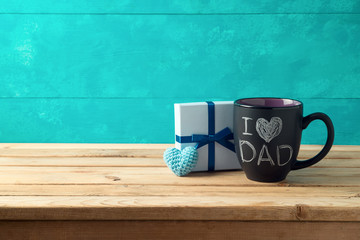 Happy Father's day concept with coffee mug and gift box over wooden background