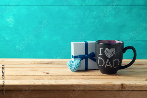 Happy Father's day concept with coffee mug and gift box over wooden background photo