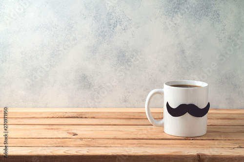 Happy Father's day concept with coffee mug and mustache over wooden background