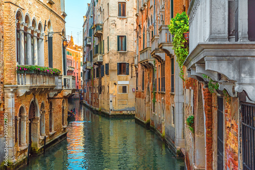 Venetian canal with gondola and colorful facades of old medieval houses in Venice, Italy © samael334