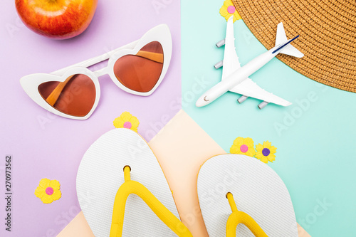 top view of summer flat lay travel background. flip flops, sunglasses and plane