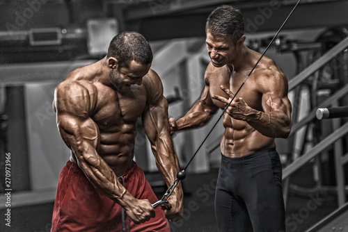 Bodybuilding Motivation. Two Bodybuilders Train Together at the Gym