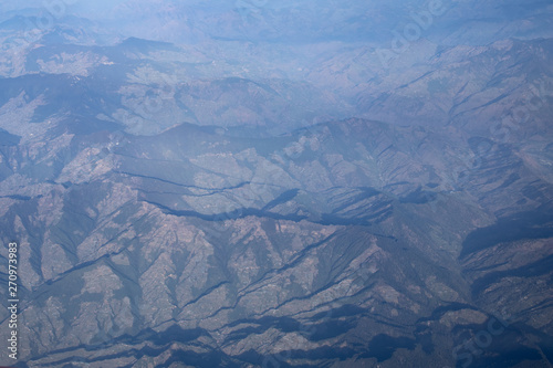 Aerial view from top of Himalayan mountains from the airplane window with Snow cover all of mountain range. Surface of white on peak hill over sky in Leh Ladakh, India.