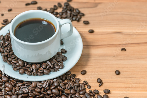 Cup of coffee and coffee beans on wooden background, Vintage tone
