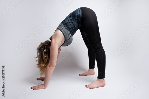 Down dog yoga pose done by flexible blonde woman