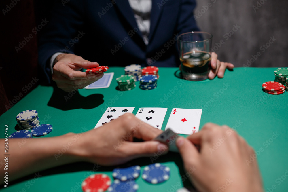 professional poker game. Green poker table with two games. poker player makes a bet by throwing chips on the table professional poker game. Green poker table with two games. poker player makes a bet by throwing chips on the table