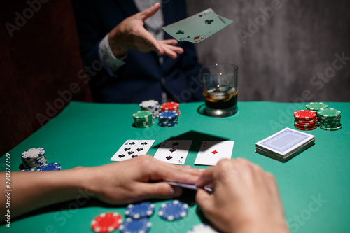 professional poker game. Green poker table with two games. poker player folds by throwing cards on the table