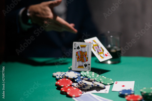 professional poker game. Green poker table with two games. poker player folds by throwing cards on the table