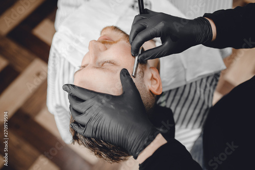Barbershop. Hairdressers barber hair and beard with razor in salon © Parilov