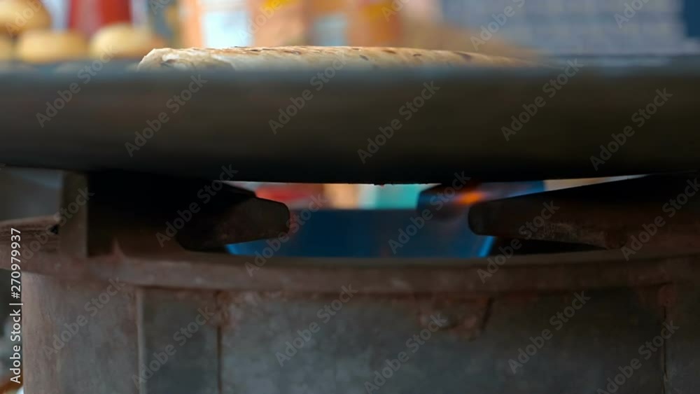 Cooking traditional indian food on metal frying pan heated on a gas stove on the street Delhi, India. Slow mo, slo mo, slow motion, high speed camera Cooking traditional indian food on metal frying pan heated on a gas stove on the street Delhi, India. Slow mo, slo mo, slow motion, high speed camera