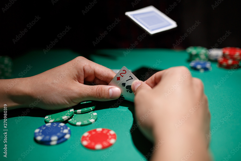 professional poker game. Green poker table with two games. poker player folds by throwing cards on the table professional poker game. Green poker table with two games. poker player folds by throwing cards on the table