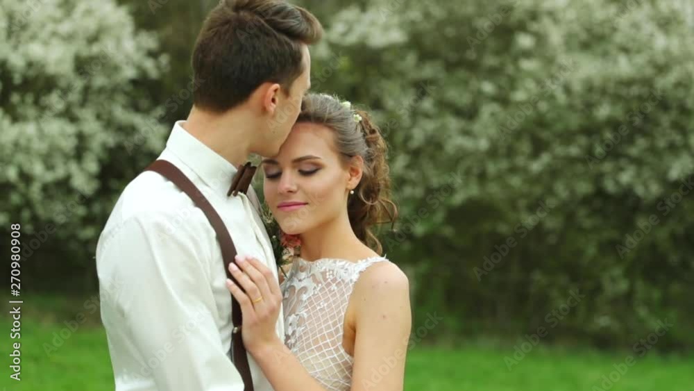 Kissing bride and groom during wedding in nature more detailed view of newlyweds in nature. Kissing bride and groom during wedding in nature more detailed view of newlyweds in nature.