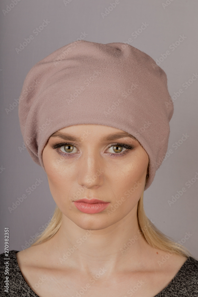 Beautiful girl with natural make-up in a headdress on a gray background. Beautiful girl with natural make-up in a headdress on a gray background.