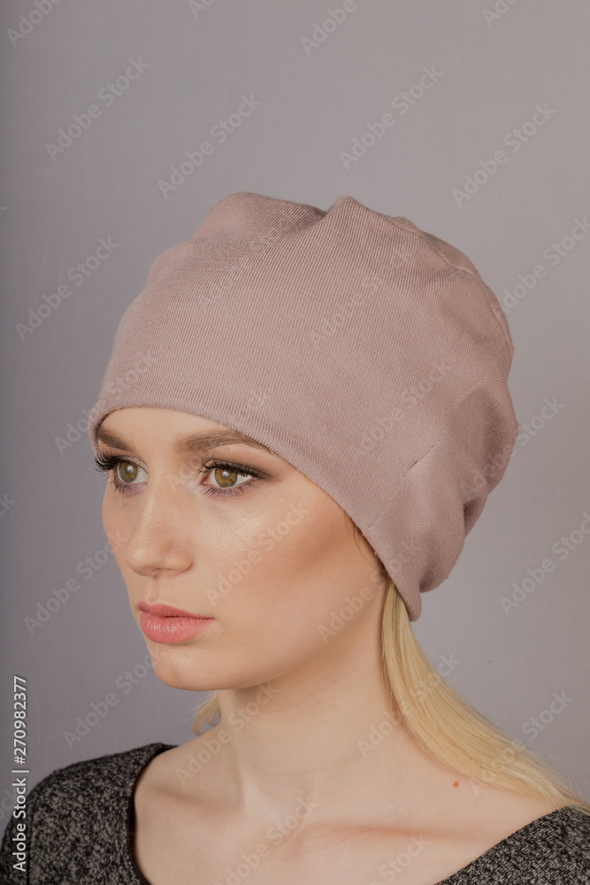 Beautiful girl with natural make-up in a headdress on a gray background. Beautiful girl with natural make-up in a headdress on a gray background.