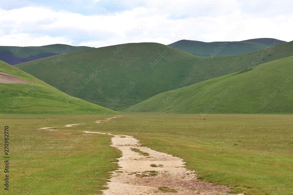 Dirt road to nowhere in the middle of The plateau of Castelluccio di Norcia (Umbria, Italy)