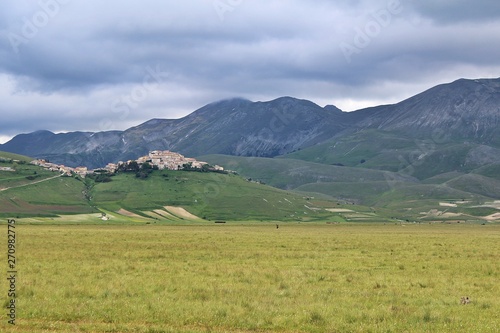 View of the plateau of Castelluccio di Norcia with the village on top of the hill (Umbria, Italy) © Daniele