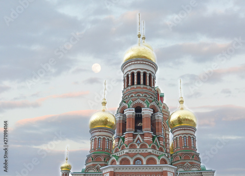 beautiful red brick Church with Golden domes on blue sky background
