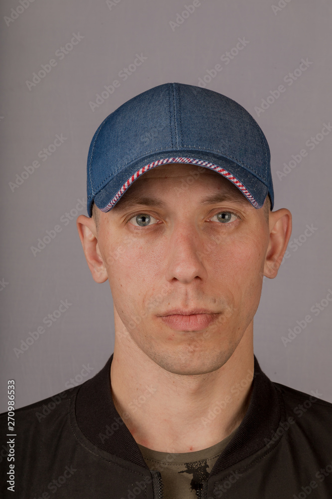 Handsome young man in a headdress on a gray background. Handsome young man in a headdress on a gray background.