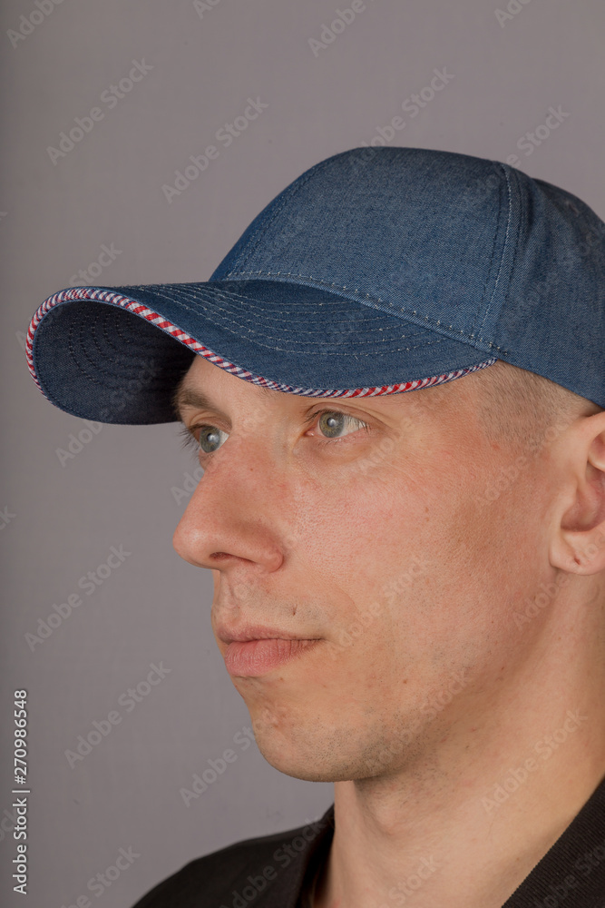 Handsome young man in a headdress on a gray background. Handsome young man in a headdress on a gray background.
