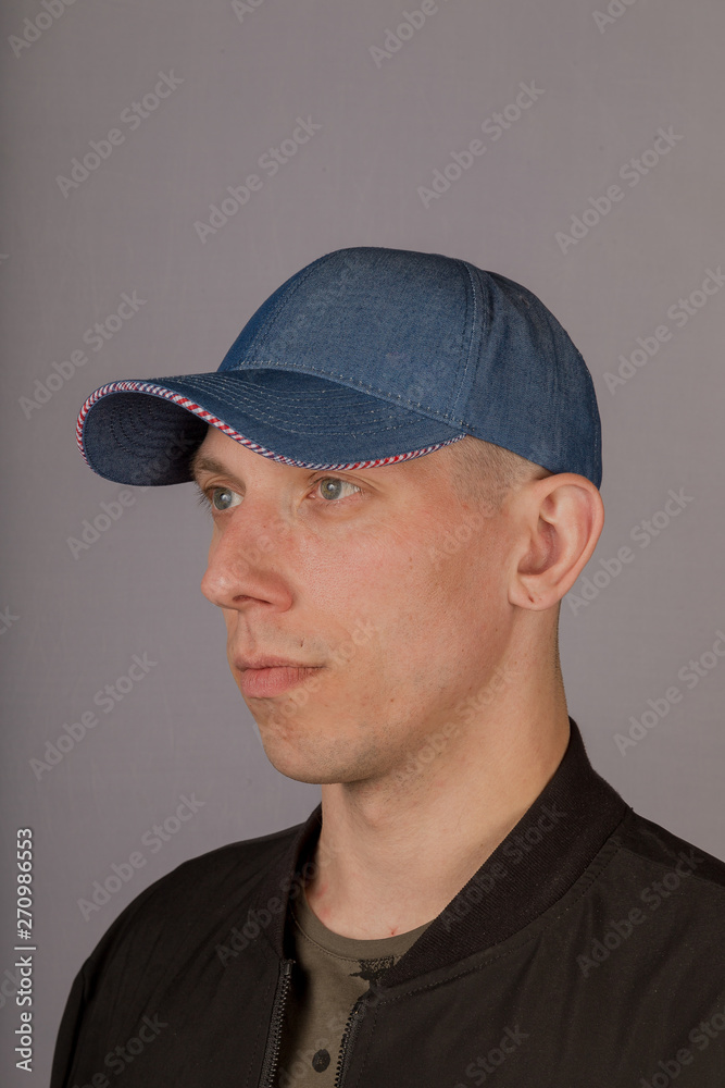 Handsome young man in a headdress on a gray background. Handsome young man in a headdress on a gray background.