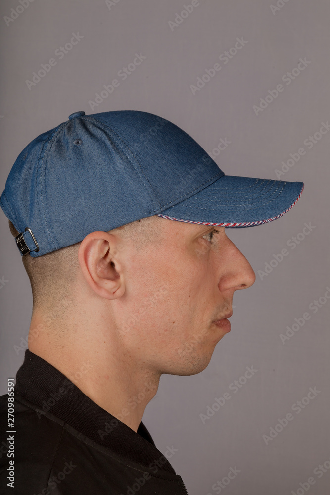 Handsome young man in a headdress on a gray background. Handsome young man in a headdress on a gray background.