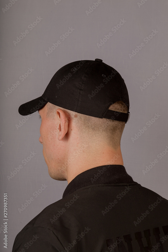 Handsome young man in a headdress on a gray background. Handsome young man in a headdress on a gray background.