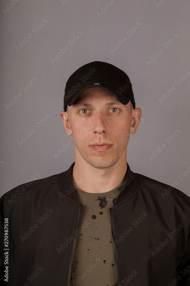 Handsome young man in a headdress on a gray background. Handsome young man in a headdress on a gray background.